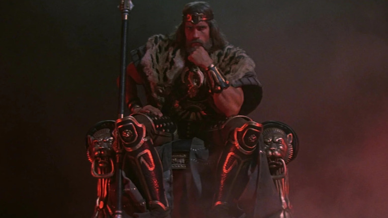 Arnold Schwarzenegger en tant que roi Conan assis sur son trône à la fin de Conan le barbare