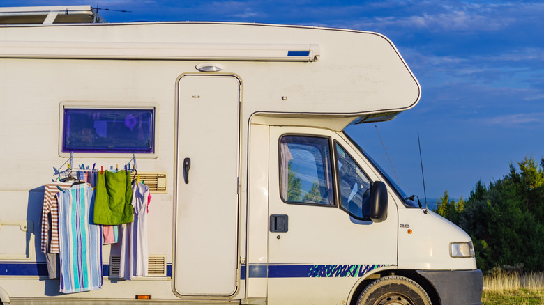 Un camping-car avec des vêtements suspendus à l'extérieur pour sécher.