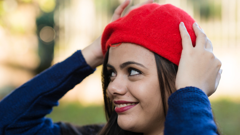 Femme souriante portant un béret rouge
