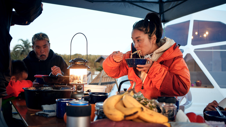 Une famille dînant dans leur camping