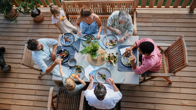 Vue de pointe de 3 générations familiales mangeant au dîner de fête de barbecue