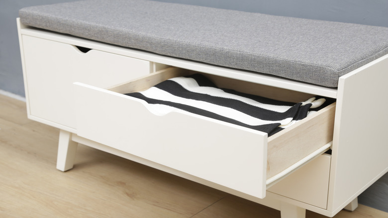 Gros plan d'un banc blanc avec des tiroirs de rangement.