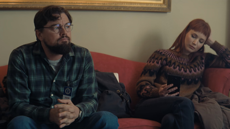 Le Dr Randall Mindy de Leonardo DiCaprio est assis à côté de Kate Dibasky de Jennifer Lawrence sur un canapé rouge dans Don't Up Up