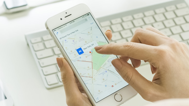 Femme utilisant l'application Appke Maps sur son iPhone.