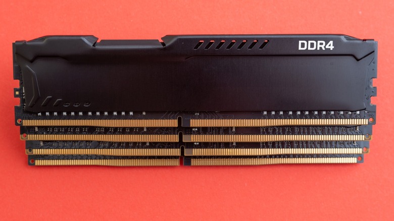 Quatre modules DDR4 empilés les uns sur les autres sur un fond orange