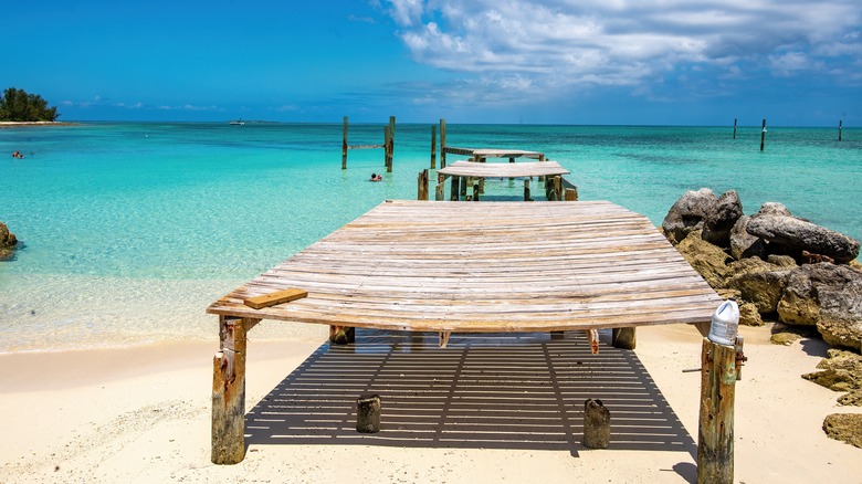 Une vieille jetée s'étend dans l'eau turquoise à Jaws Beach, Bahamas