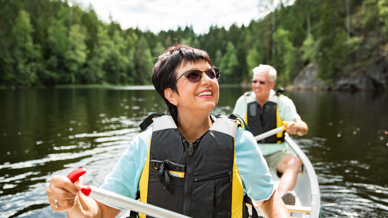 Un couple kayak dans un lac bordé en Finlande