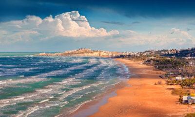 Une plage pittoresque en Italie possède de superbes falaises de calcaire, du sable doré et de l'eau peu profonde