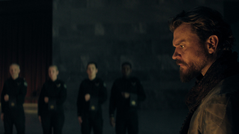 Pilou Asbæk comme la mule se baignait d'une lumière chaude et debout devant les serviteurs dans la saison de fondation 3