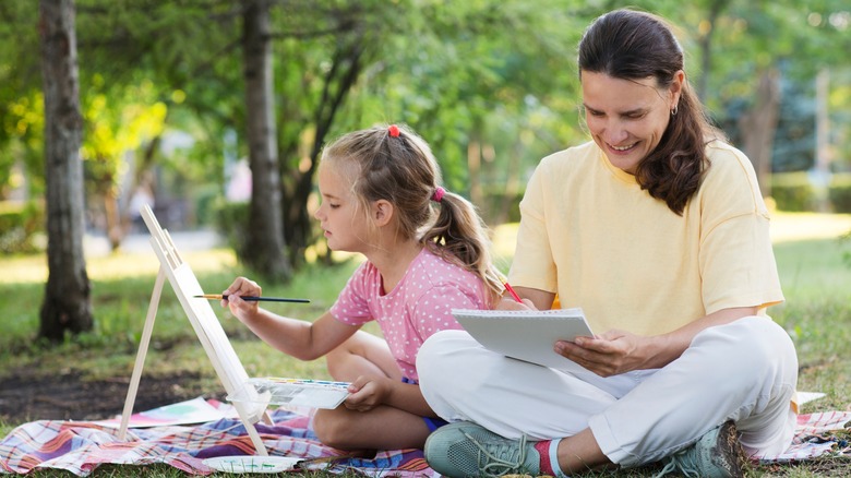 Femme et fille peignant et dessin dans un parc