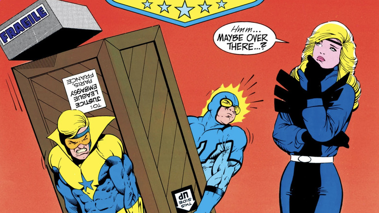 Couverture de Justice League International # 8: Blue Beetle et Booster Gold portant une boîte lourde alors que Black Canary considère où le mettre