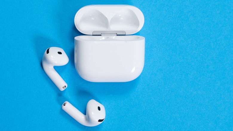 AirPods 4 Éditeurs sans fil et casse de charge ouverte sur un fond bleu vibrant