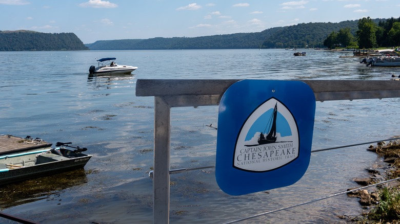 Signale pour le capitaine John Smith National Historic Trail sur un quai, avec des bateaux naviguant en arrière-plan