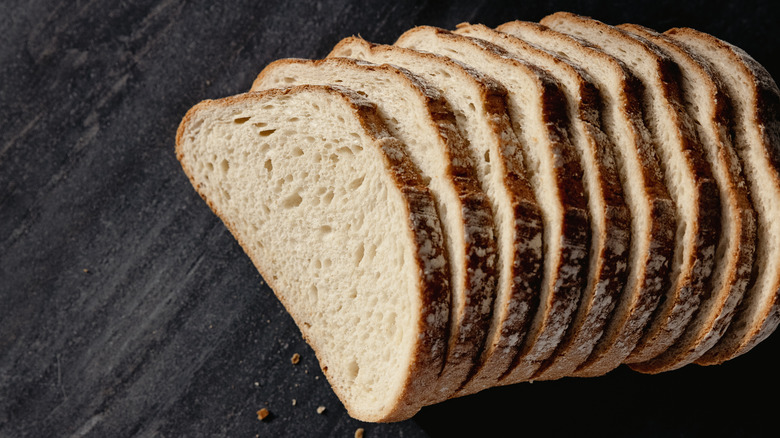 Le pain tranché se trouve sur une surface sombre