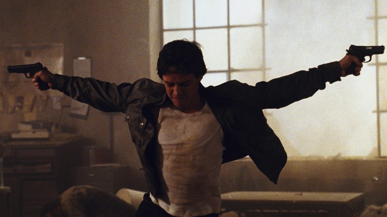 James McAvoy en tant que Wesley tenant ses pistolets sur ses côtés, les yeux fermés dans Wanted