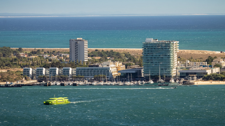 Une vue aérienne d'un ferry dans l'eau avec des bâtiments entourés d'eau bleue