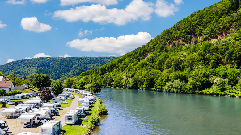 Vue aérienne d'un camping de VR sur une rivière avec des collines environnantes