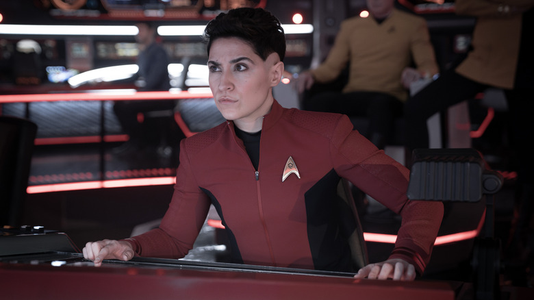 Celia Rose Gooding comme Uhura, Mynor Luken comme Beto, et Melissa Navia comme Erica Ortegas debout près d'un bar et tenant des boissons dans de nouveaux mondes étranges