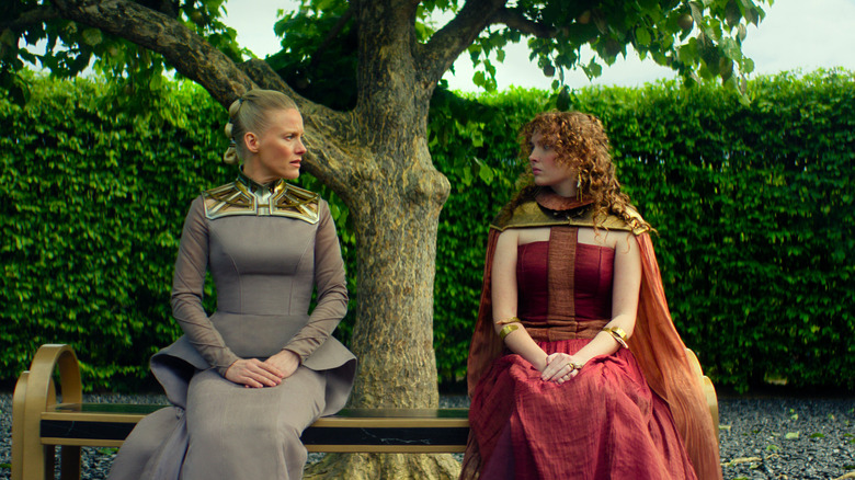 Laura Birn en tant que Demerzel et Rebecca Ineson comme Zephyr Vorellis assis sur un banc de parc dans la saison 3