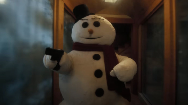 Un bonhomme de neige tenant un pistolet dans le pistolet nu