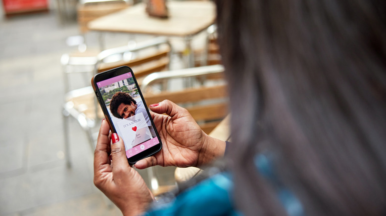 Une femme vérifiant le profil d'un homme sur une application de rencontres