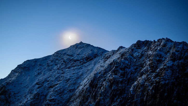 La lune se levant derrière le sommet de Snowdon Mountain au Pays de Galles