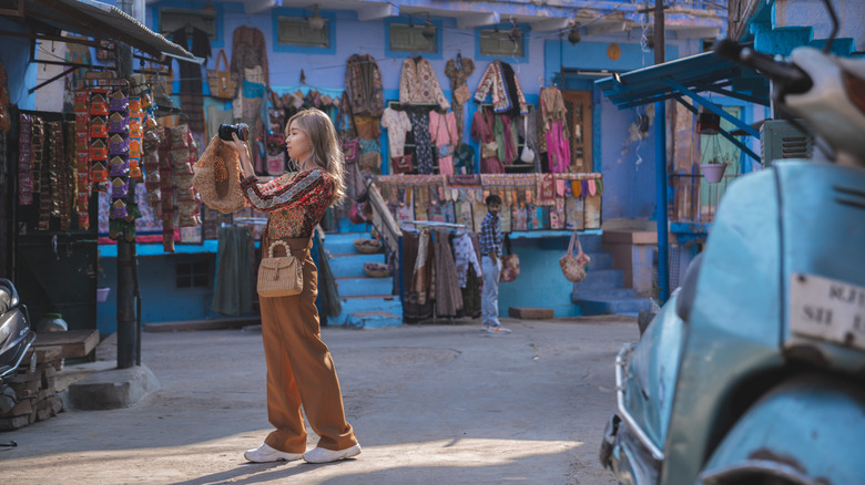 Une femme prend des photographies sur un marché en Inde