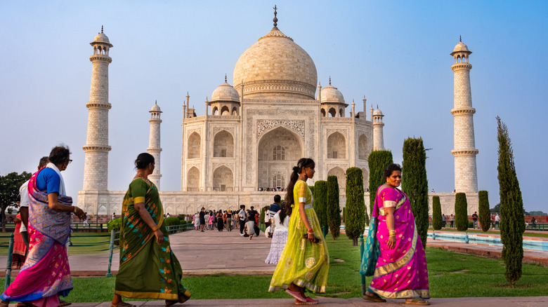 Une file d'attente de femmes en saris colorée passe devant le Taj Mahal