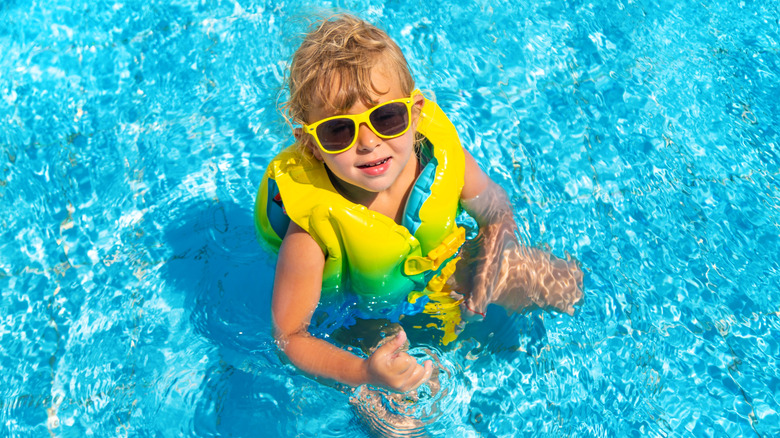Enfant portant un gilet de sauvetage dans la piscine