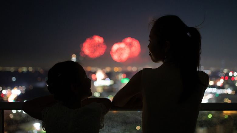 parents et enfants qui regardent des feux d'artifice