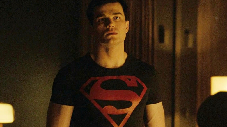 Conner se tient dans une pièce avec un T-shirt Superman en Titans