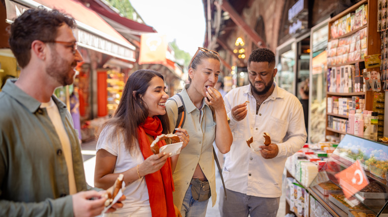 Un groupe d'amis grignotant sur un marché