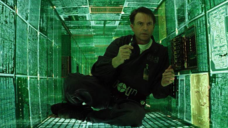 Sam Neill en tant que Dr Weir entouré de panneaux vert vert dans Horizon d'événements