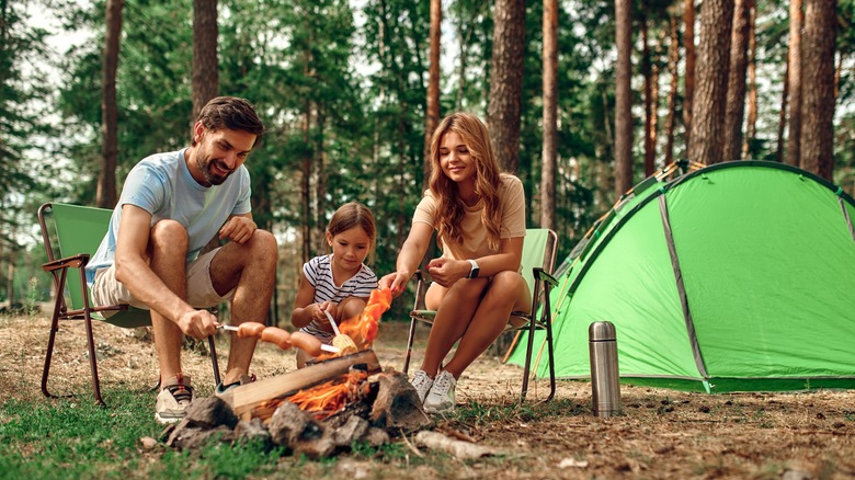 Famille à la cuisson d'un incendie dans un camping