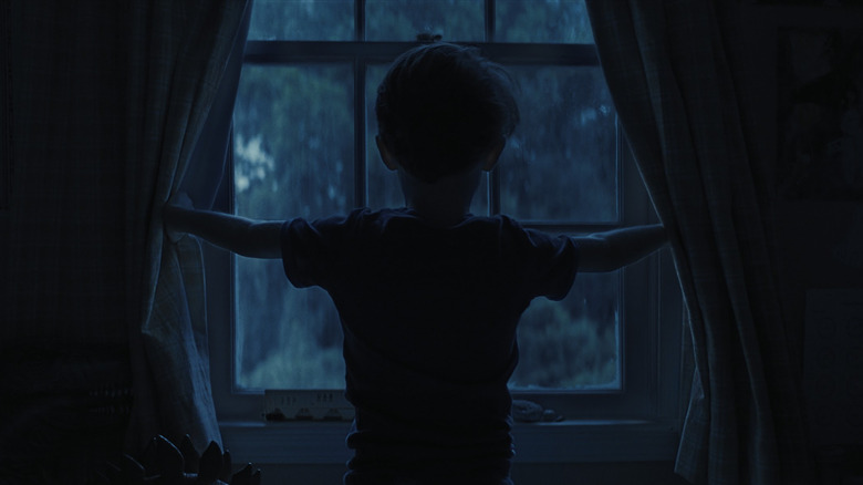 Alex Lilly ouvrant les rideaux dans les armes