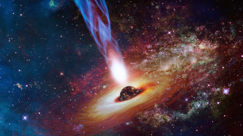 Un quasar dans l'espace profond est vu entouré d'étoiles et de poussière d'espace