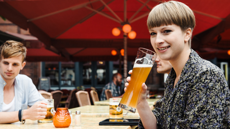Une femme tenant un verre de bière
