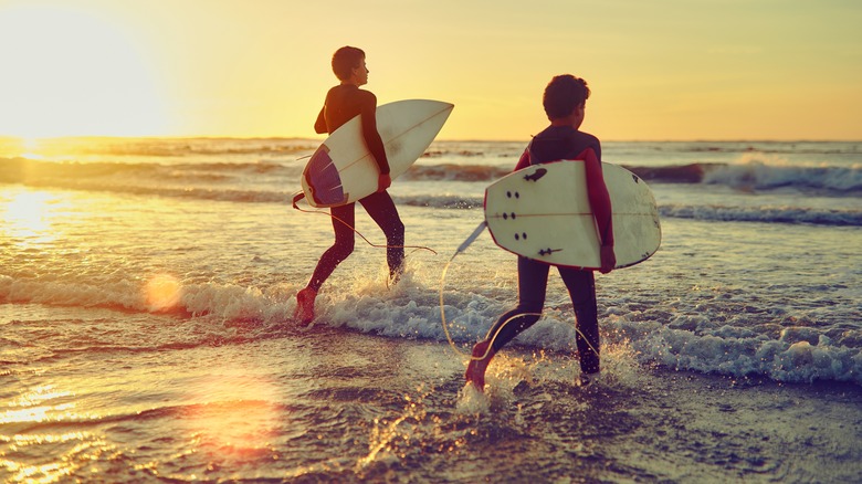 Deux surfeurs qui courent dans l'océan
