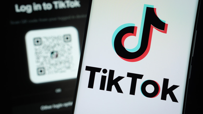 Le Tiktok affiché sur un écran de smartphone, un autre téléphone est visible en arrière-plan.