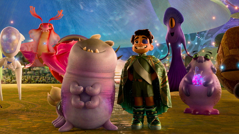 Elio souriant, entouré d'autres extraterrestres de la Communniverse, à Elio