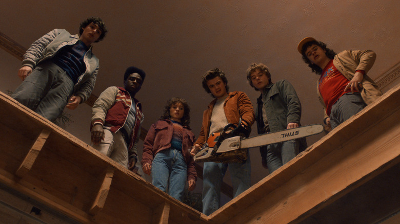 Lucas, Dustin, Steve, Nancy, Jonathan et Mike regardant dans un trou d'en haut dans Stranger Things Saison 5