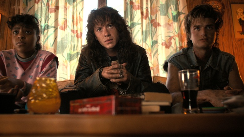 Erica, Eddie et Steve sont assis sur un canapé dans Stranger Things Saison 4