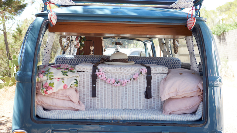 Ouvert à l'arrière d'un camping-car rétro avec des bagages et des coussins