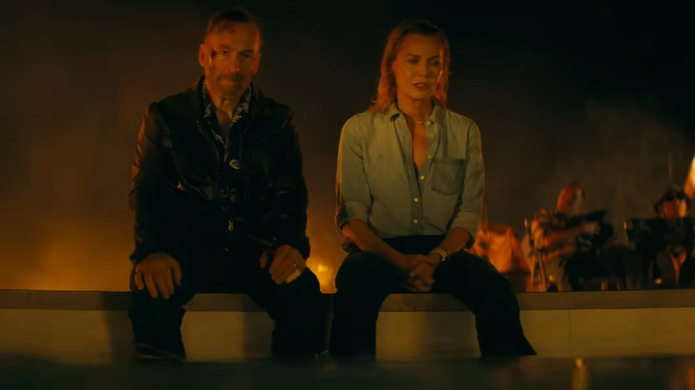 Hutch et Becca assis au sommet d'une piscine dans Nobody 2