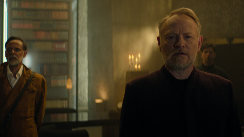 Alexander Siddig en tant que docteur Ebling Mis debout à côté de Jared Harris comme Hari Seldon dans une bibliothèque de fondation
