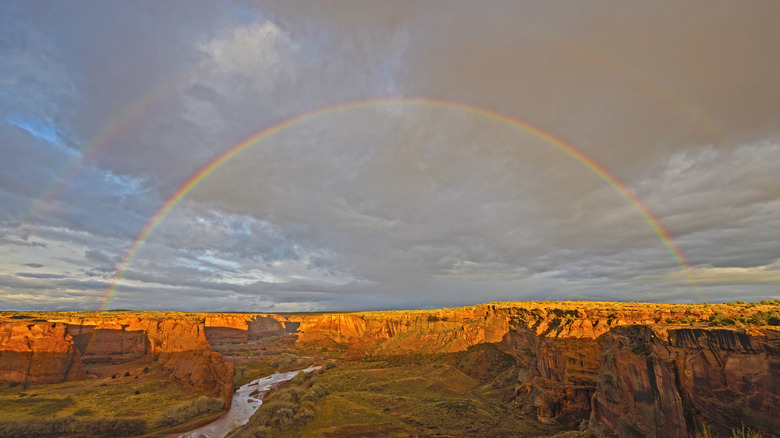 Un double arc-en-ciel sur des canyons rouges profonds