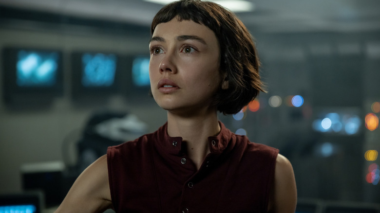 Sydney Chandler en tant que Wendy debout dans une pièce pleine d'équipement informatique et regardant un écran à l'étranger: Terre