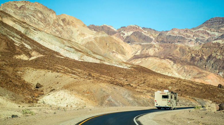 Un VR conduisant autour d'un virage d'une autoroute avec des montagnes et du désert