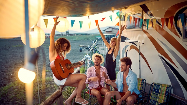 Les campeurs faisant la fête avec une guitare