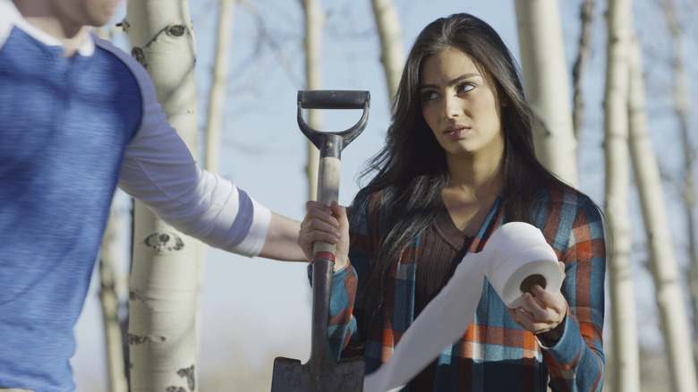 Femme avec pelle et papier toilette